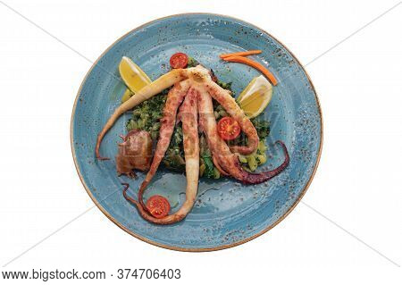 Balkan Cuisine. Plate With Grilled Octopus And Green Leafy Vegetables Isolated On White. Flat Lay