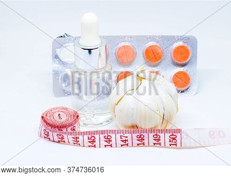 Medicine, Garlic And Tailors Centimeter. Weight Control Or Slimming Diet Concept Photo. Medical Or C