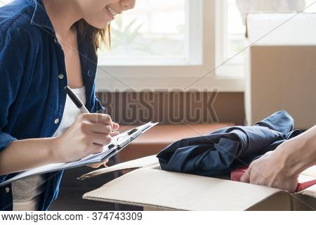 Happy Woman Checking Stuff In Cardboard Box Before Sent To Transportation Company And Moving To New 