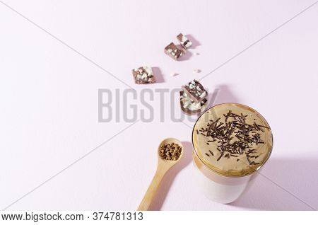 Korean Coffee Dalgon In High Glass On A Light Background. Nearby Lies A Wooden Spoon With Coffee And