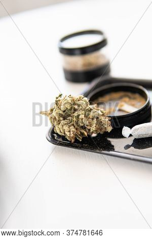 The Pot Leaves On Buds Cbd. Thc Kief In Grinder. White Background Vartical Shot.