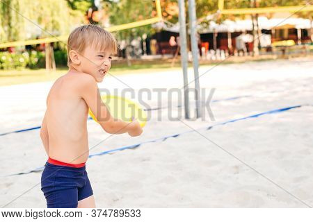 Cute Boy Playing With  On The Beach. Happy Kid Having Fun Outdoors In Sunny Day. Child Spending Care