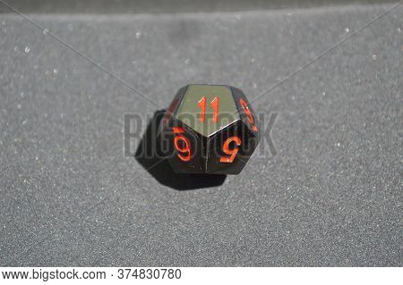 Black Metallic D12 Twelve Sided Dice On Foam Surface