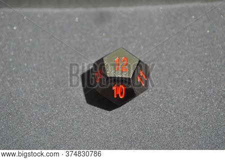 Black Metallic D12 Twelve Sided Dice On Foam Surface