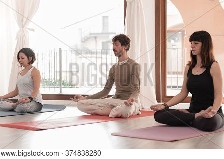 Yoga Teachers Sitting In The Lotus Position With Their Eyes Closed. Group Of People Practicing Yoga.