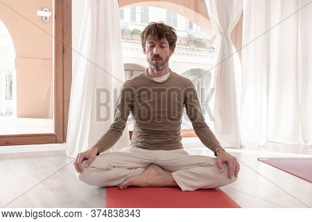 Yoga Teacher Sitting In The Lotus Position With Their Eyes Closed. Man Practicing Yoga. How To Keep