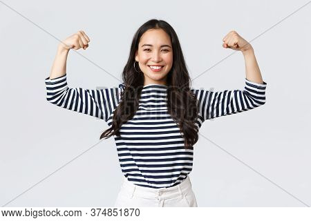 Lifestyle, People Emotions And Casual Concept. Strong And Confident Asian Woman Flex Biceps, Braggin
