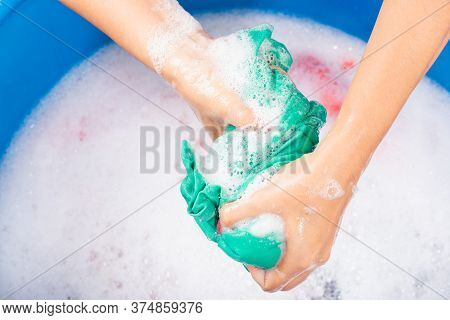 Closeup Young Asian Woman Use Hands Washing Color Clothes In Basin. Female Squeeze Wring Out Wet Fab