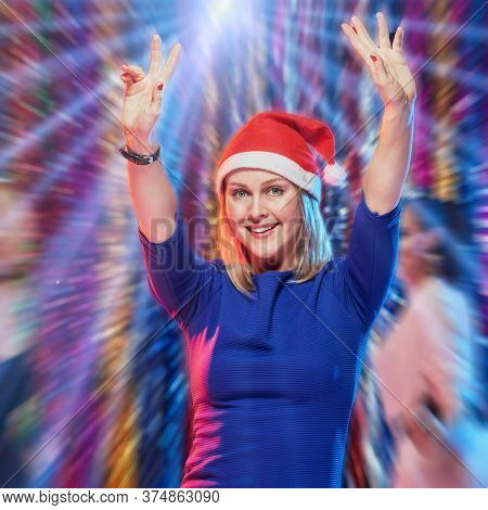 Attractive Blonde In Xmas Cap Dancing On New Year Lights Background