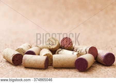 Corks From Wine Bottles Lie In A Pile On A Wooden Background. Natural Fon With Heap Of Corks From Re