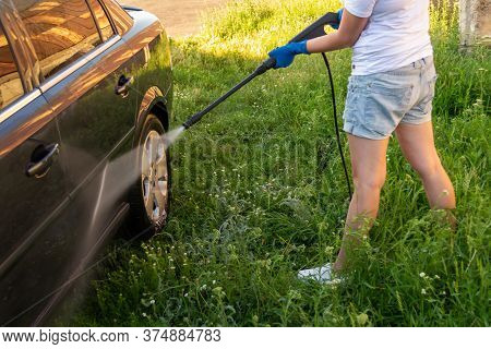 Car Wash, A Woman In Blue Gloves Washes A Car With A Karcher