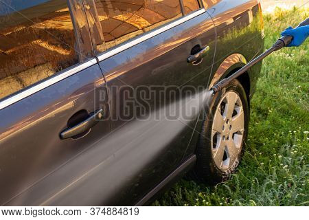 Car Wash, A Woman In Blue Gloves Washes A Car With A Karcher