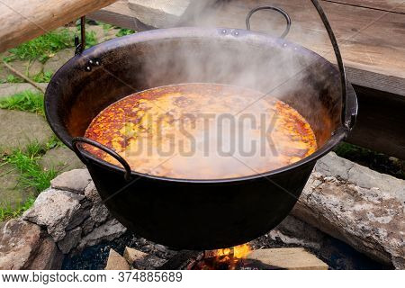 Traditional Hungarian Bogracs Goulash Soup. Cooking Dish On Open Fire In A Cauldron. Preparing Healt