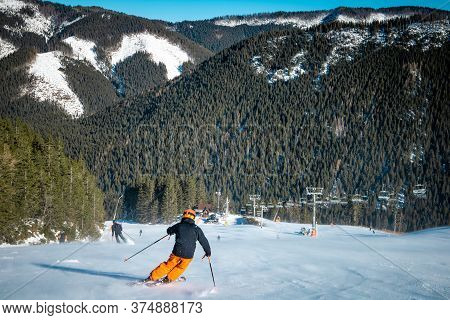 Teenage Male Skier Turning On A Slope During Sunny Day