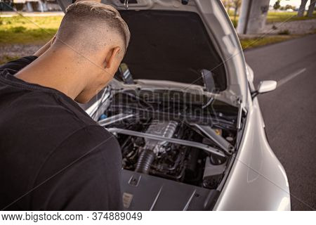 Young Male Taking A Look At His Car Engine With The Hood Popped