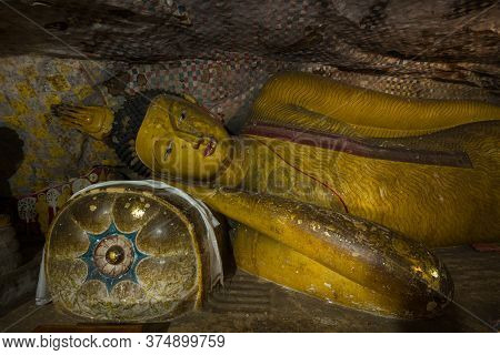Dambulla, Sri Lanka - February 80, 2020: Ancient Statue Of A Reclining Buddha In A Cave Buddhist Tem