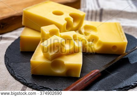 Block Of Swiss Medium-hard Yellow Cheese Emmental Or Emmentaler With Round Holes And Cheese Knife Cl