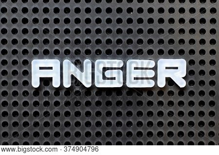 White Color Alphabet With Word Anger On Black Pegboard Background
