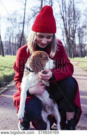 Pretty Young Girl In Redd Coat Playing With Dog Outside In Green Park, Lifestyle People Concept