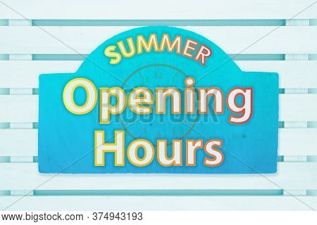 Summer Opening Hours Type Message With A Sun On A Green Wood Sign In Pale Green Wood Slats Board