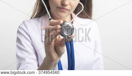 Close Up Portrait Of Unrecognizable Caucasian Doctor Woman With Stethoscope Holding Using In Directi