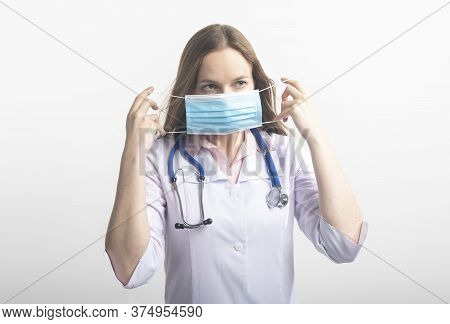 Female Doctor Surgeon Putting A Facial Mask On Standing With Stethoscope Isolated On White Backgroun