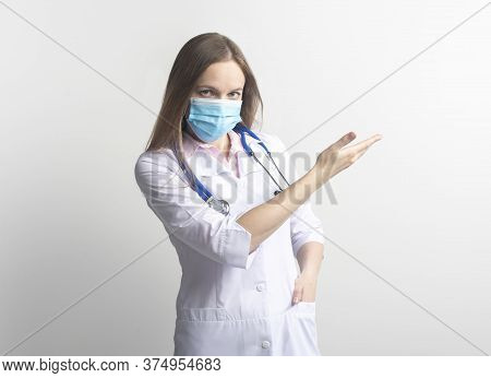 Happy Serious Female Young Doctor Wearing Facial Mask Uniform And Stethoscope Pointing With Finger O