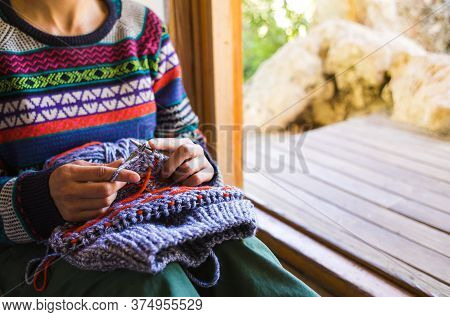 Female Hands Close-up, Young Woman Is Knitting. Knitting Needles And Threads. Multi-colored Yarn. Ha