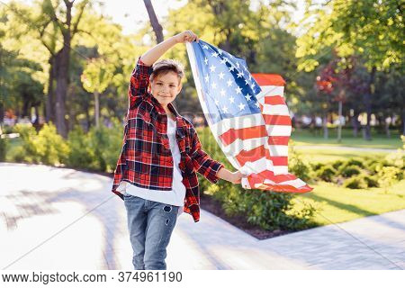 U.s. Independence Day. A Young Guy American Or Caucasian, 8 Years Old Riding At The Speed On A Skate
