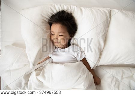Small Preschool Cute Vietnamese Ethnicity Baby Girl Sleeping In Bed.