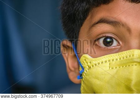 Isolated Young Indian Boy With Prominent Eyes Wearing N95 Face Mask For Protection Against Covid 19.
