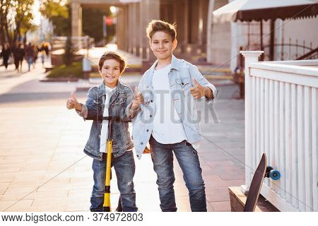 Two Attractive Teenagers Of Caucasian Nationality 7 And 9 Years Old Standing On Sunny Evening Street