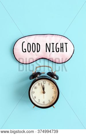 Good Night Text On Pink Sleep Mask For Eyes And Black Alarm Clock On Blue Background. It S Midnight 