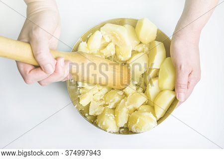 Cooking Potato Pie Fillings (quiche, Dumplings). Female Hands Hold A Wooden Potato Masher In The Hom