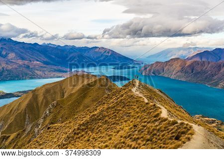 New Zealand hiking people on mountain top Roys Peak enjoying active outdoor lifestyle arms raised cheering happy in New Zealand nature landscape, near Wanaka, Otago, South Island, New Zealand.