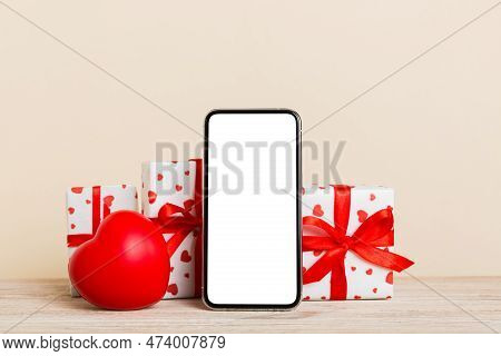 Mobile Phone With Blank Screen On Colored Background With Hearts, Calendar And Gift Box, Valentine D