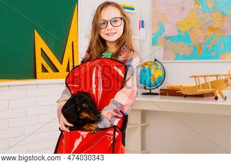Home Schooling. Funny Little Pupil Wearing Glasses. Pupil Of Primary School With Puppy. Girl With Go