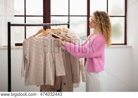 Portrait Of Young Stylist Woman Picking Trendy Clothing At Fashion Studio