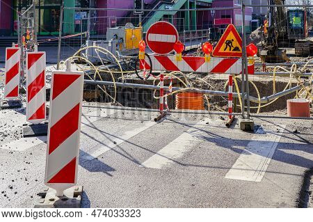 Street Repair Site With Red And White Striped Vertical Warning Bollards, Signs, Barrier, Temporary M