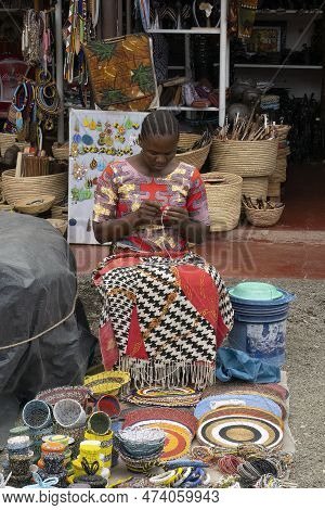 Arusha, Tanzania - October 17th, 2022: A Woman Making And Selling Colorful Bead Products In The Arus