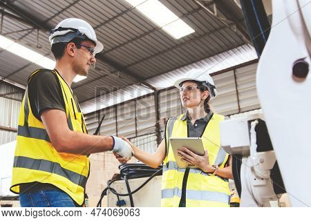 Male And Female Electrician Engineers Shaking Hands Working Together As A Team To Inspect Modern Ele