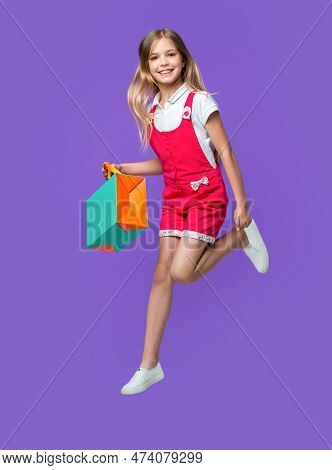 Teen Girl Jumping After Shopping On Background. Photo Of Teen Girl Jumping After Shopping