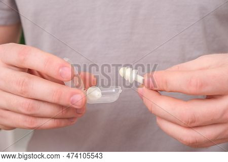 Man Inserts Earplugs So As Not Hear Extraneous Noise, Music, Snoring. Silicone Earplugs For Sleeping