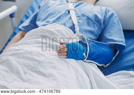 Injured Patient Showing Doctor Broken Wrist And Arm With Bandage In Hospital Office Or Emergency Roo