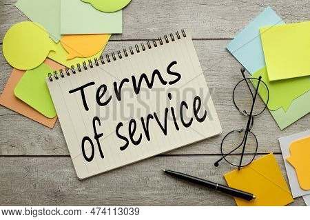 Terms Of Servise. A Lot Of Stickers Are Scattered On A Wooden Background With Text On A Notepad
