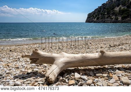 Sandy Beach And Calm Water Of Thracian Sea (mediterranean). Rock Covered By Vegetation.  Pile Of Col