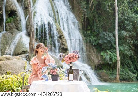 Young Asian Woman Sitting On A Chair In Front Of The Khoun Moung Keo Waterfall