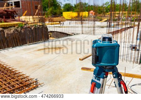 Total Center Device With Laser For Leveling Other Devices To Level Construction Site. Workers Measur