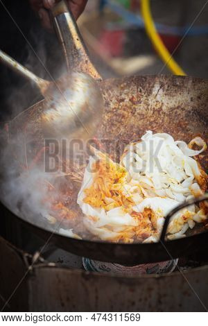 Cooking Fried Kue Teow Noodles In A Wok At A Local Stall In Asia.