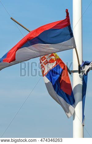 Torn And Weathered Flag Of Serbia On A Post Waving In Wind, Selective Focus
